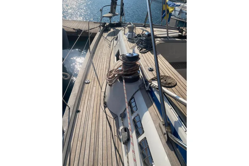  Yacht Photos Pics Deck of 2007 Hallberg-Rassy 54 yacht with ropes and winch, docked by the water.