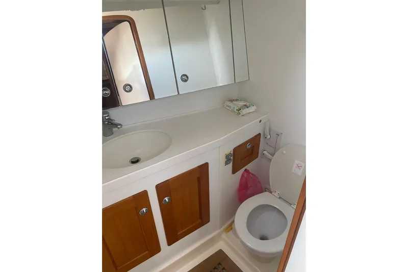  Yacht Photos Pics Bathroom interior of 2007 Hallberg-Rassy 54 yacht with sink, mirror, and toilet.