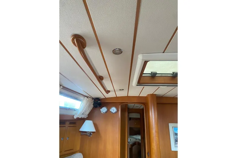  Yacht Photos Pics Interior of 2007 Hallberg-Rassy 54 yacht with wooden paneling and ceiling details.