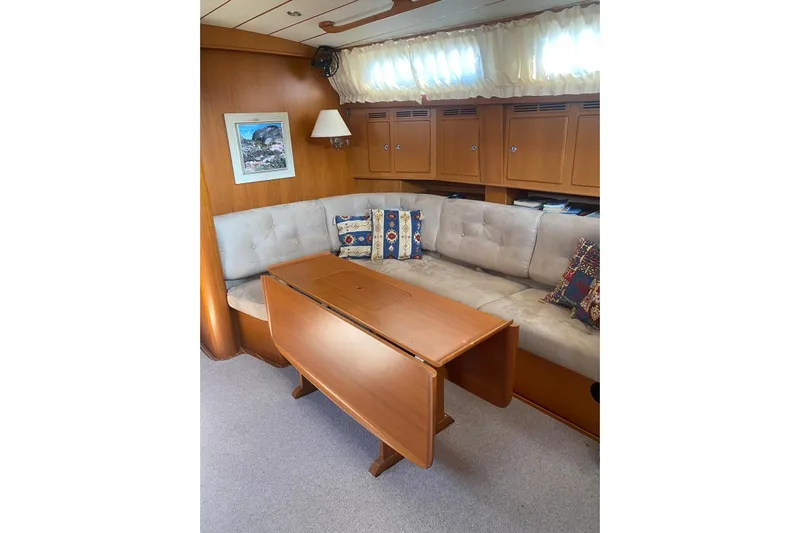  Yacht Photos Pics Luxurious 2007 Hallberg-Rassy 54 yacht interior with cozy seating and wooden table.