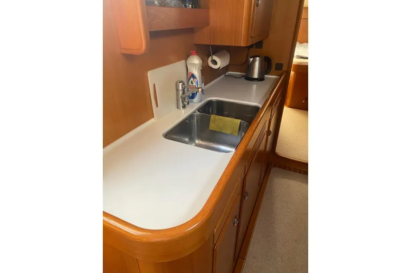  Yacht Photos Pics Galley kitchen in 2007 Hallberg-Rassy 54 yacht with sink and wooden cabinetry.