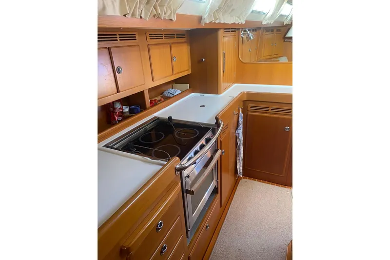  Yacht Photos Pics 2007 Hallberg-Rassy 54 yacht kitchen with wooden cabinets and modern stove.