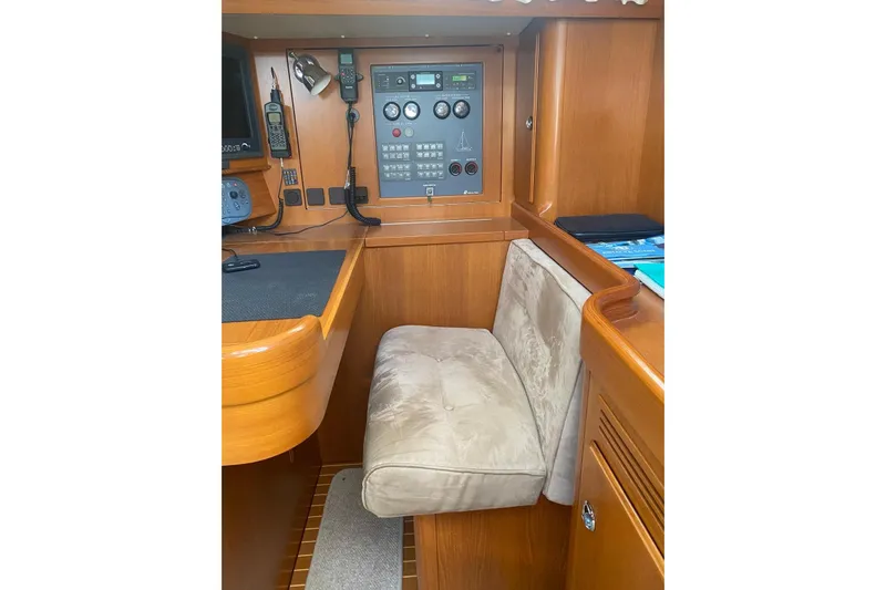  Yacht Photos Pics Navigation station of 2007 Hallberg-Rassy 54 yacht with control panel and seating.