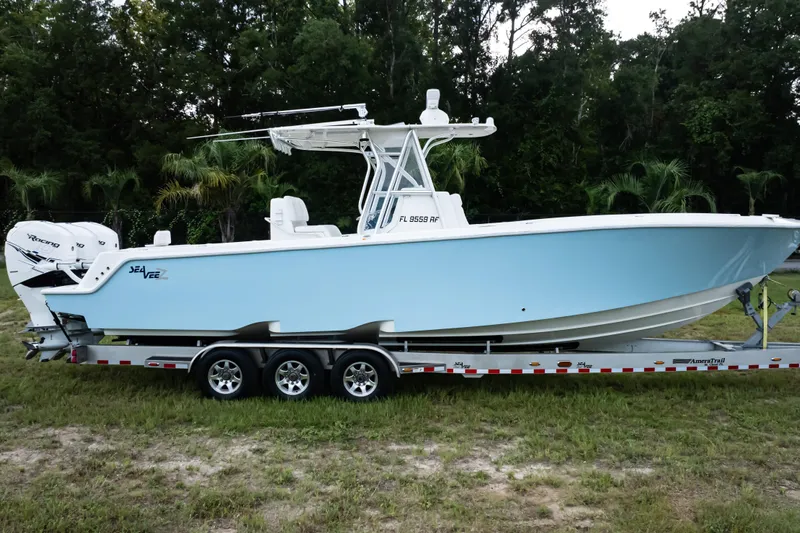  Yacht Photos Pics 2017 SeaVee 340Z boat on trailer, light blue hull, parked on grass.