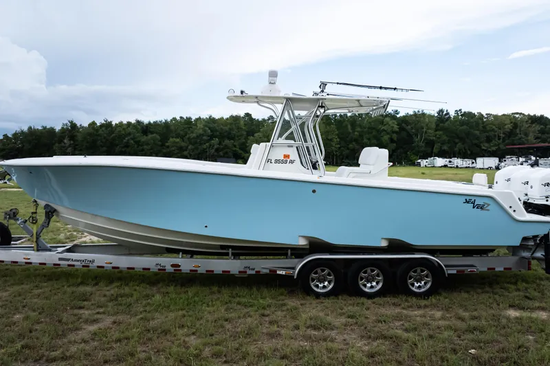  Yacht Photos Pics 2017 SeaVee 340Z boat on trailer, light blue hull, parked on grass.