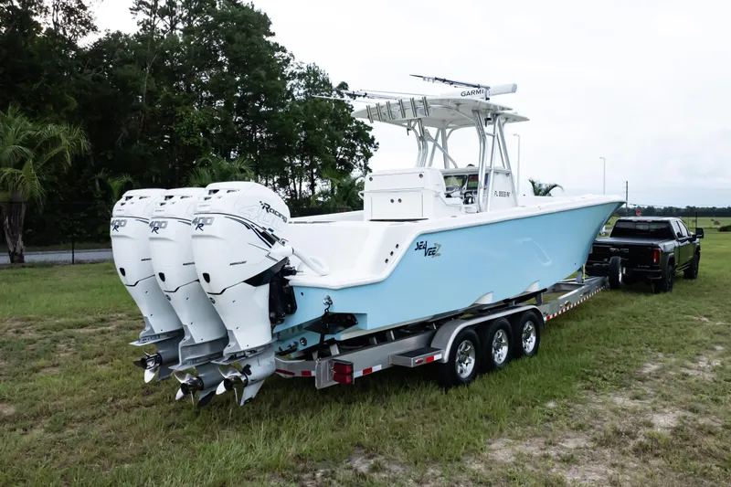  Yacht Photos Pics 2017 SeaVee 340Z boat on trailer with triple outboard engines, parked on grass.