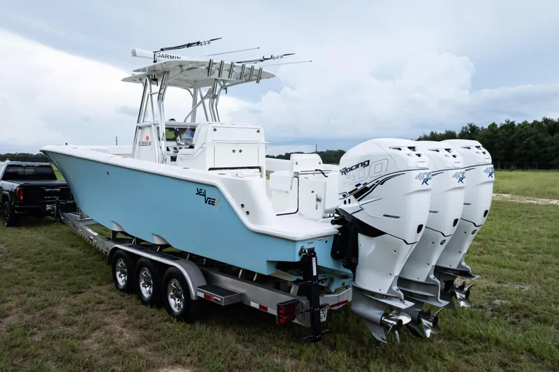  Yacht Photos Pics 2017 SeaVee 340Z boat with triple outboard engines on a trailer in a grassy area.