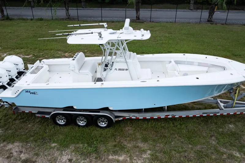  Yacht Photos Pics 2017 SeaVee 340Z boat on trailer, light blue hull, triple engines, parked on grass.
