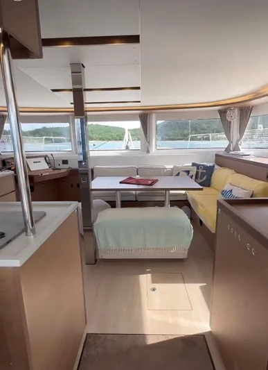  Yacht Photos Pics Interior of 2022 Lagoon 46 catamaran with modern furnishings and panoramic windows.