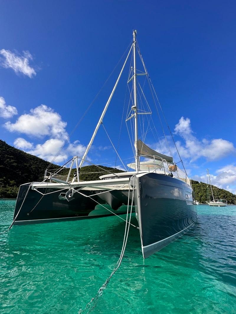 2022 Lagoon 46 catamaran anchored in clear turquoise water under a bright blue sky.