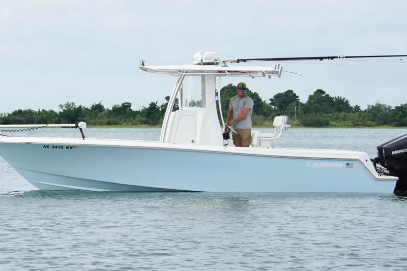  Yacht Photos Pics 2024 Contender 25 Tournament boat on water, man fishing, serene background.