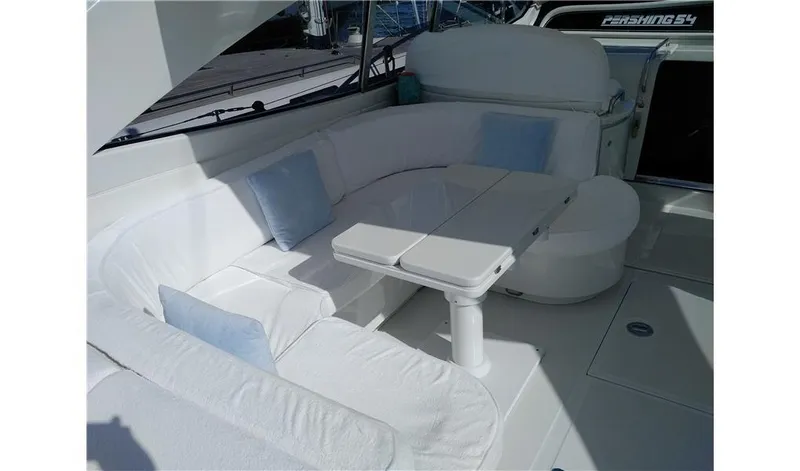  Yacht Photos Pics Luxurious white seating area on a 2002 Pershing 54 yacht with cushions and table.
