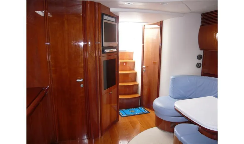  Yacht Photos Pics Luxurious interior of 2002 Pershing 54 yacht with wooden finishes and blue seating.