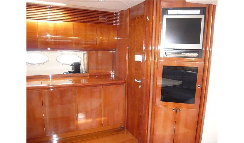  Yacht Photos Pics Luxurious wooden interior of a 2002 Pershing 54 yacht with built-in TV and storage.