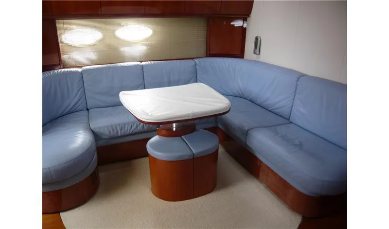  Yacht Photos Pics Interior of 2002 Pershing 54 yacht with blue leather seating and wooden table.