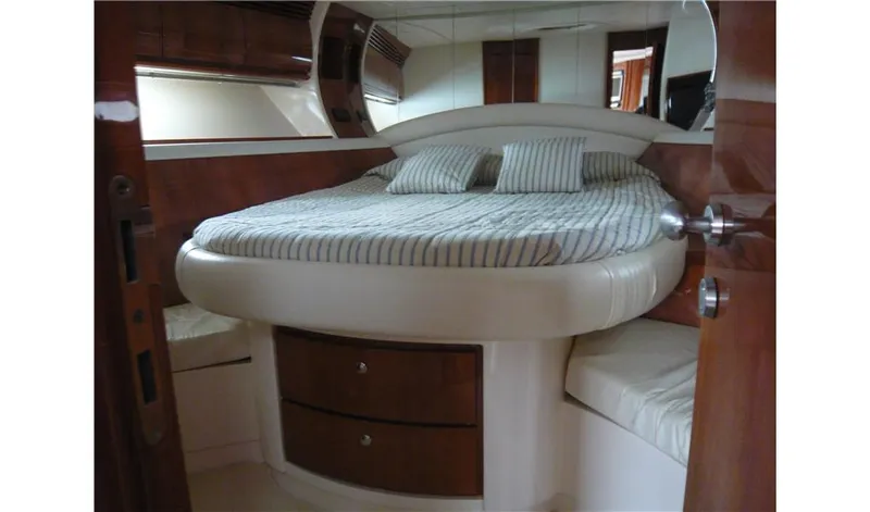  Yacht Photos Pics Luxurious bedroom interior of 2002 Pershing 54 yacht with striped bedding and wooden accents.