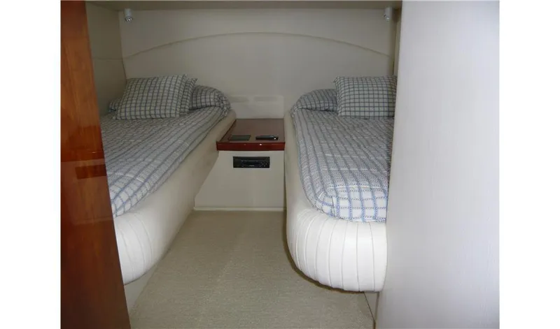  Yacht Photos Pics Interior cabin of 2002 Pershing 54 yacht with twin beds and checkered bedding.