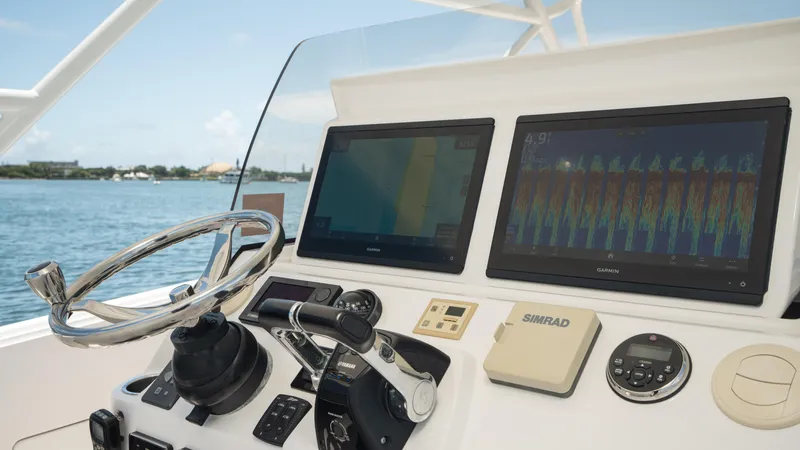  Yacht Photos Pics Intrepid 400 Cuddy 2013 helm with dual displays and steering wheel, overlooking water.