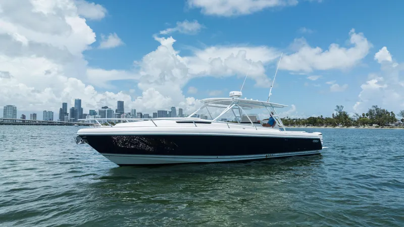  Yacht Photos Pics 2013 Intrepid 400 Cuddy boat on water with city skyline background.