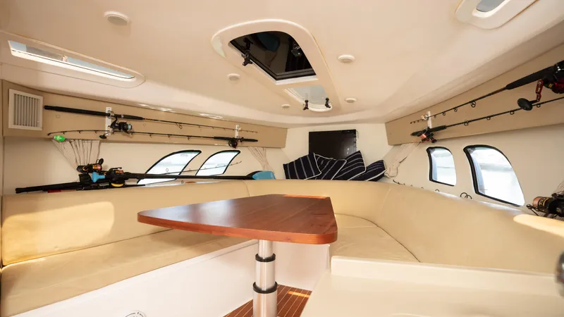  Yacht Photos Pics Interior of 2013 Intrepid 400 Cuddy with beige seating and wooden table.