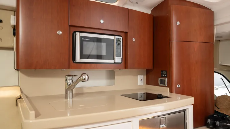  Yacht Photos Pics 2013 Intrepid 400 Cuddy kitchen with microwave, sink, and wooden cabinets.