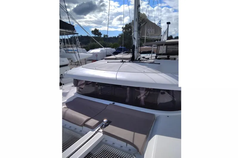 Stolos Yacht Photos Pics 2020 Lagoon 42 catamaran docked, featuring sleek design and spacious deck under a cloudy sky.