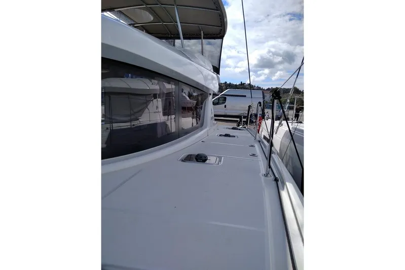Stolos Yacht Photos Pics 2020 Lagoon 42 catamaran deck view with clear skies and marina backdrop.