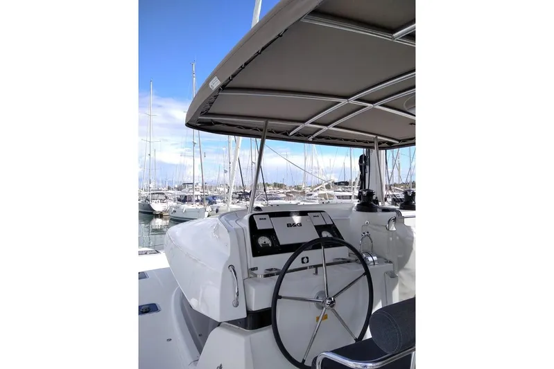 Stolos Yacht Photos Pics Helm of 2020 Lagoon 42 catamaran in marina, featuring steering wheel and navigation equipment.