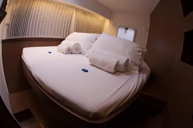 Stolos Yacht Photos Pics Luxurious cabin interior of 2020 Lagoon 42 yacht with neatly arranged bed and towels.