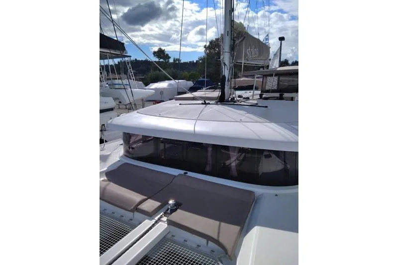 Stolos Yacht Photos Pics 2020 Lagoon 42 catamaran with sleek design, docked under a partly cloudy sky.