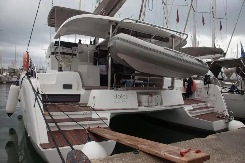 Stolos Yacht Photos Pics 2020 Lagoon 42 catamaran docked, featuring a spacious deck and dinghy.