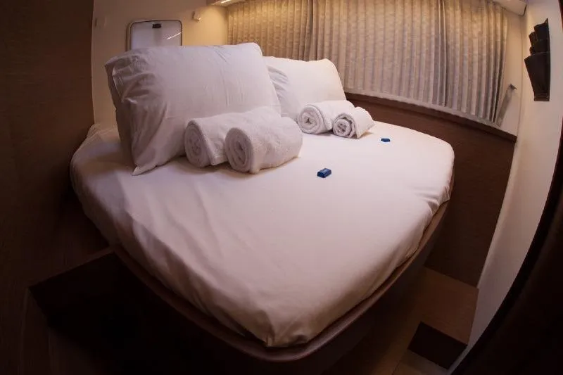 Stolos Yacht Photos Pics Luxurious cabin interior of 2020 Lagoon 42 yacht with neatly arranged bed and towels.