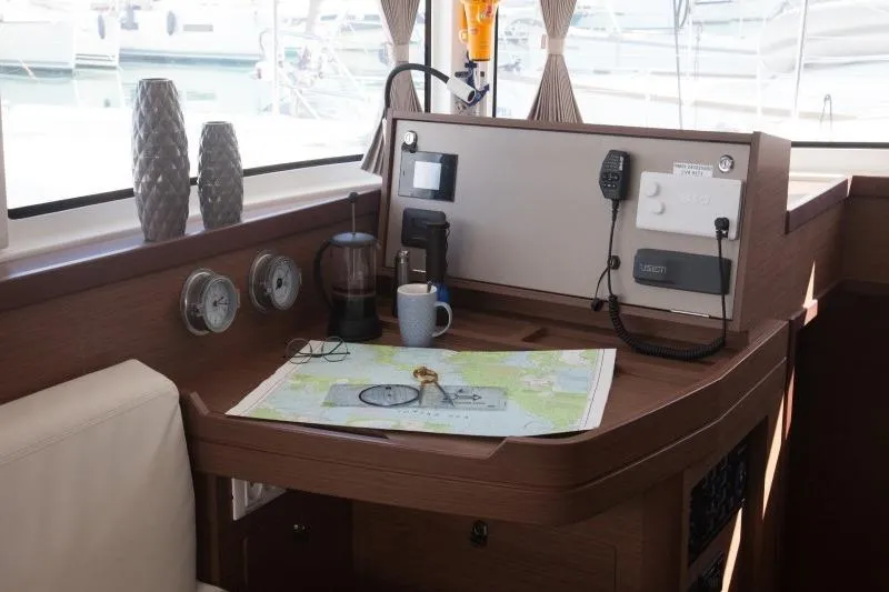 Stolos Yacht Photos Pics Navigation station on 2020 Lagoon 42 catamaran with map, compass, and communication equipment.