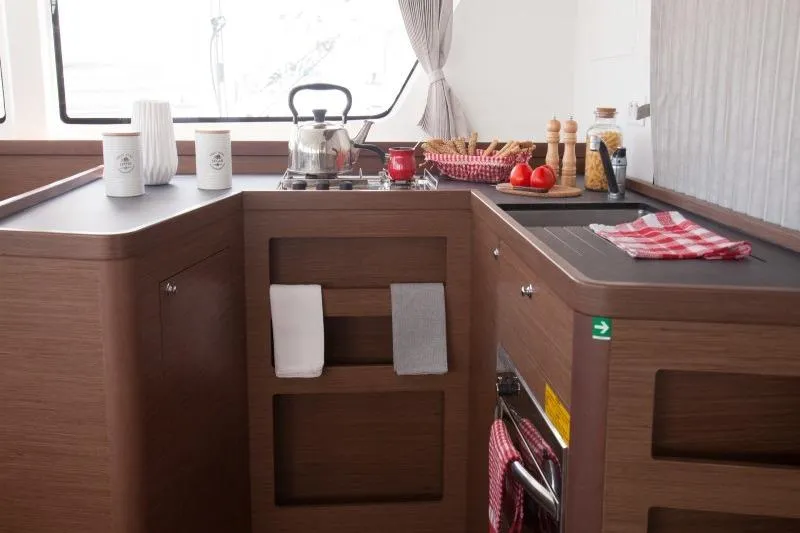Stolos Yacht Photos Pics Modern kitchen interior of 2020 Lagoon 42 yacht with wooden cabinetry and cooking essentials.