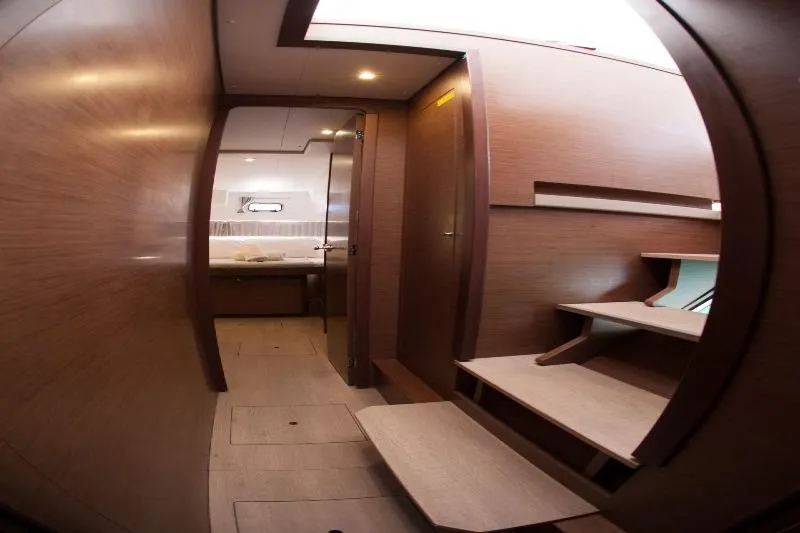 Stolos Yacht Photos Pics Interior of 2020 Lagoon 42 yacht, featuring wooden stairs and cozy cabin.