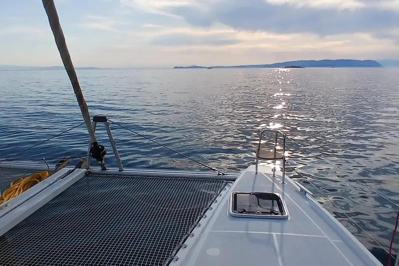 Stolos Yacht Photos Pics Lagoon 42 catamaran sailing on calm sea at sunset, 2020 model.