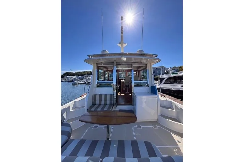 Independence Yacht Photos Pics 2012 Sabre 42 Salon Express yacht with sunlit deck and striped seating.