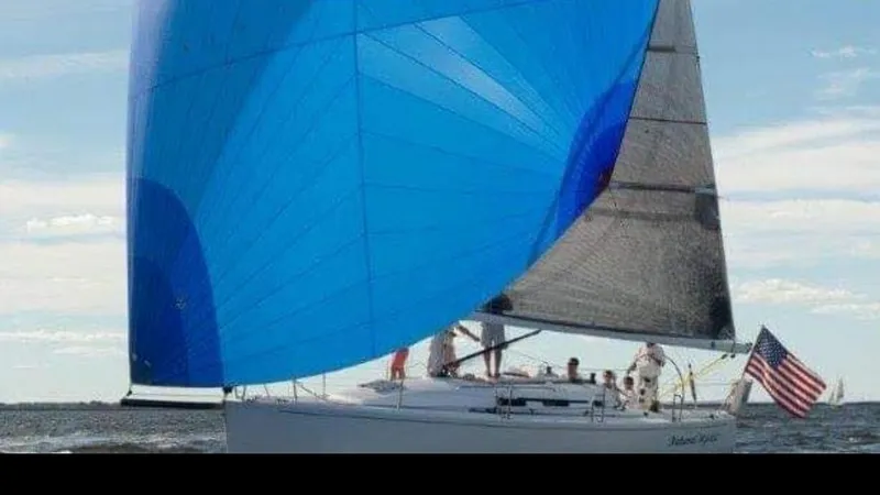 Natural Mystic Yacht Photos Pics 2003 J Boats J/109 sailing with blue spinnaker and American flag on open water.