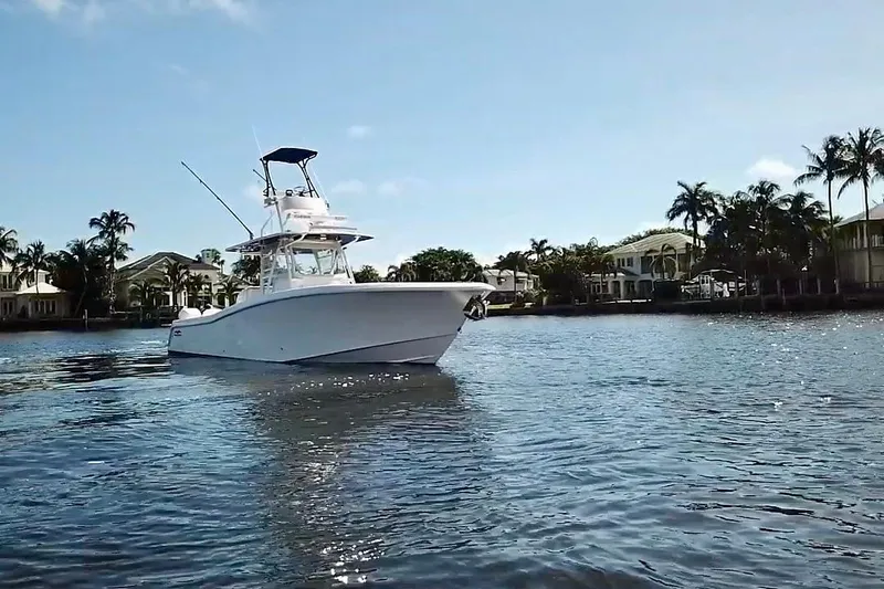  Yacht Photos Pics 2020 Invincible 39 Open Fisherman boat on calm water, surrounded by palm trees.