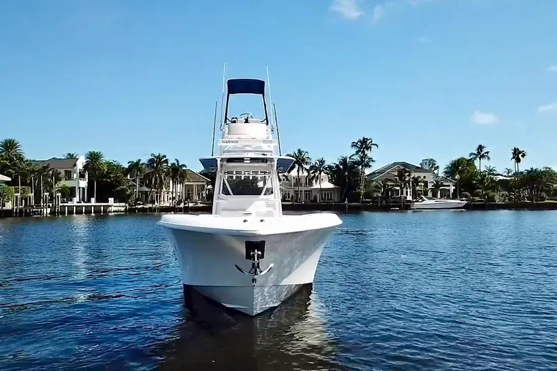  Yacht Photos Pics 2020 Invincible 39 Open Fisherman boat on a sunny waterfront with palm trees.