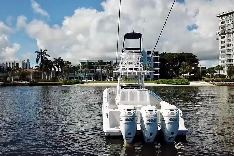 Yacht Photos Pics 2020 Invincible 39 Open Fisherman boat with triple engines on calm water.