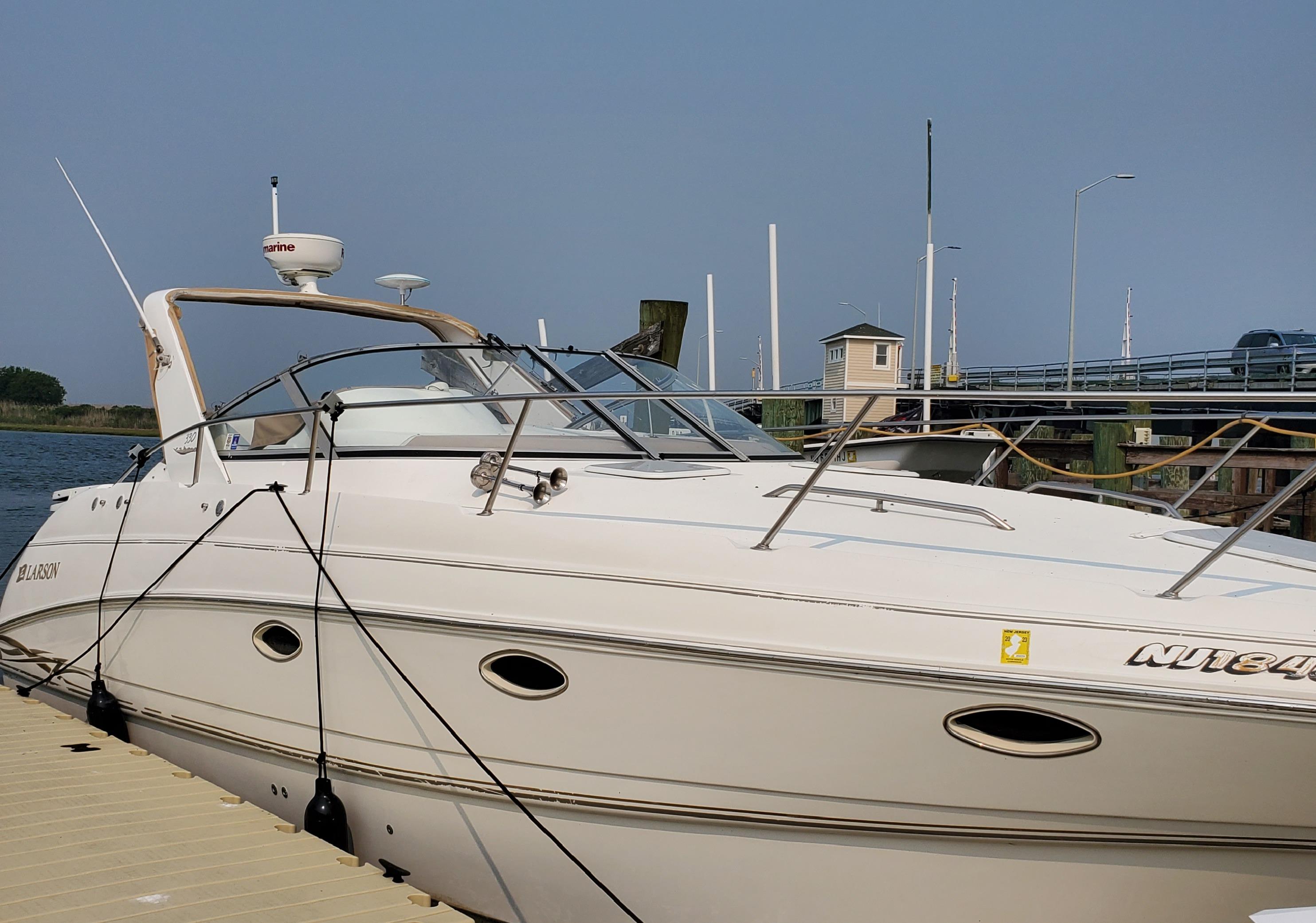 2000 Larson 330 Cabrio boat docked at marina, side view.