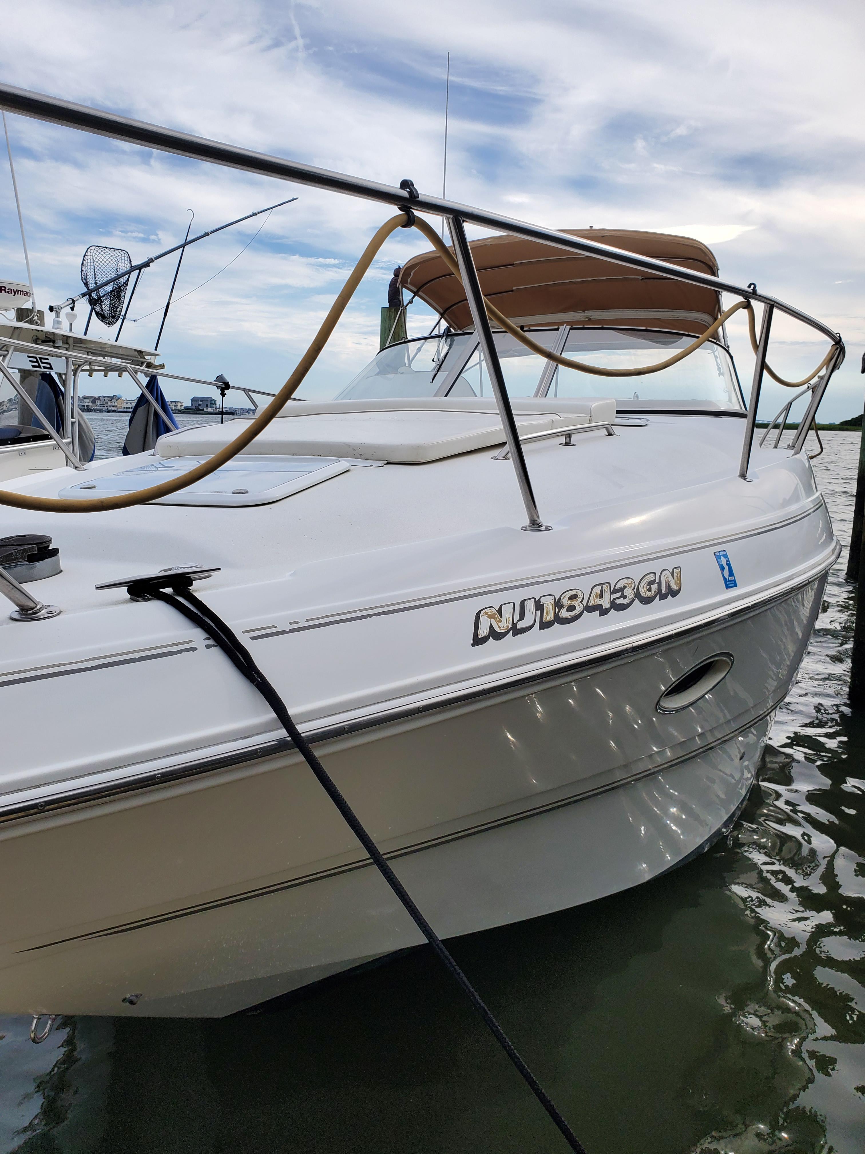2000 Larson 330 Cabrio boat docked, featuring sleek design and visible registration number.