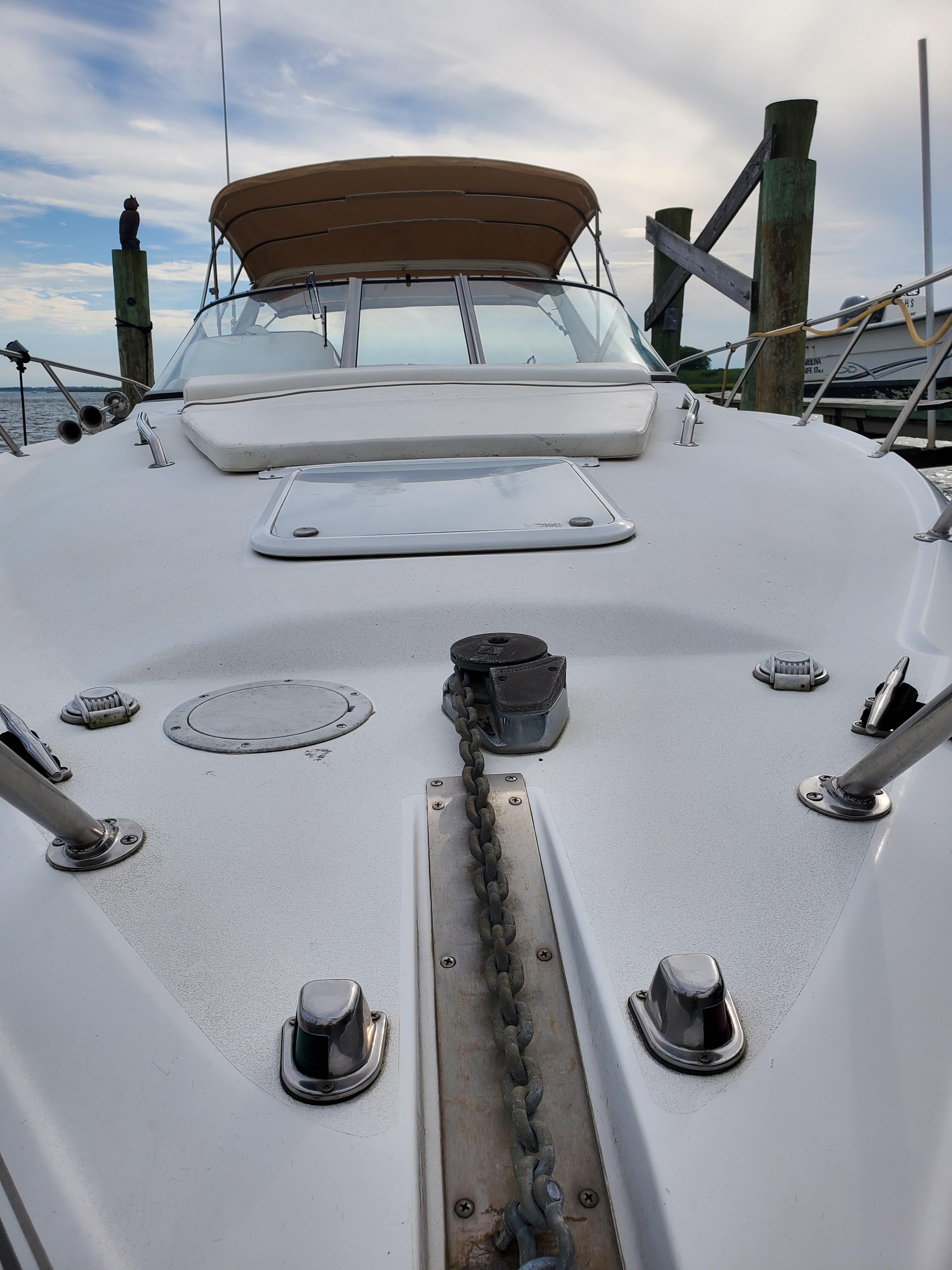 2000 Larson 330 Cabrio boat deck with anchor chain and canopy, docked at marina.