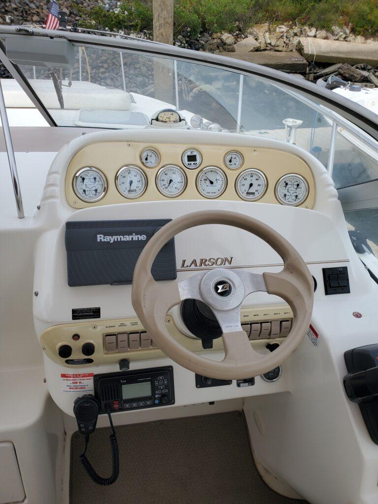 Steering console of a 2000 Larson 330 Cabrio boat with gauges and controls.