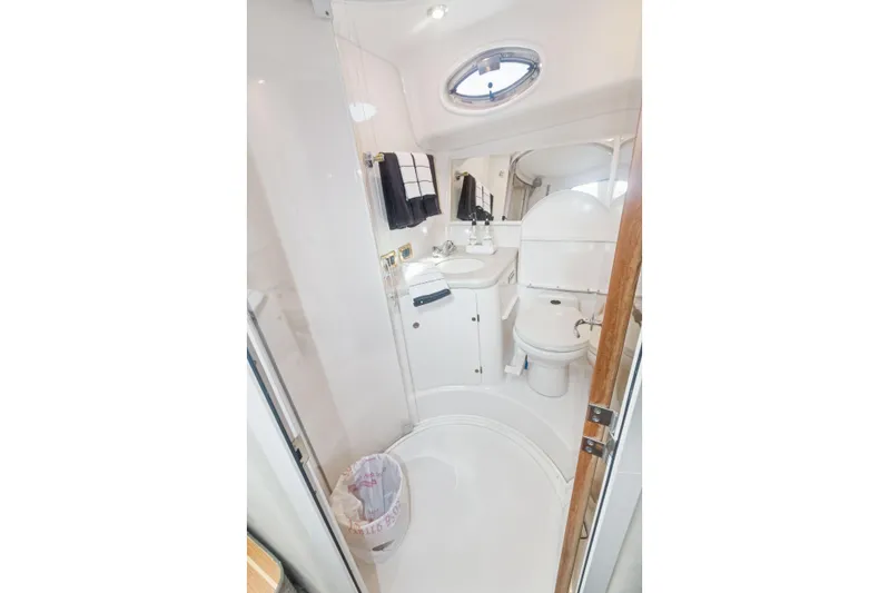 Sandie Lee Yacht Photos Pics Bathroom interior of 2000 Sea Ray 370 Express Cruiser, featuring sink, toilet, and mirror.