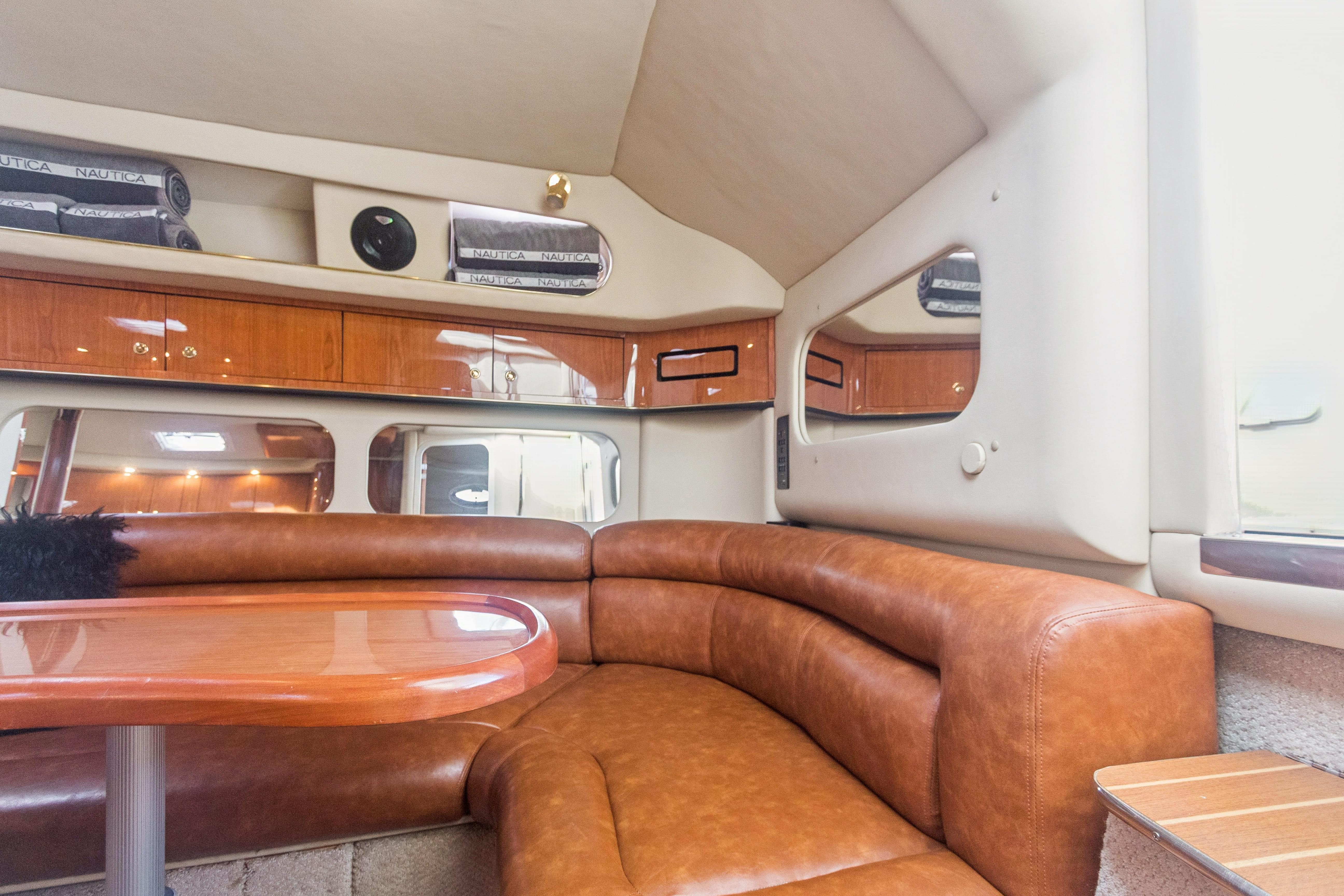 Luxurious interior of 2000 Sea Ray 370 Express Cruiser with leather seating and wooden accents.