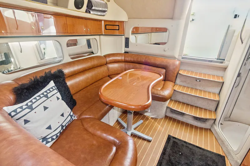 Sandie Lee Yacht Photos Pics Interior of 2000 Sea Ray 370 Express Cruiser with leather seating and wooden table.