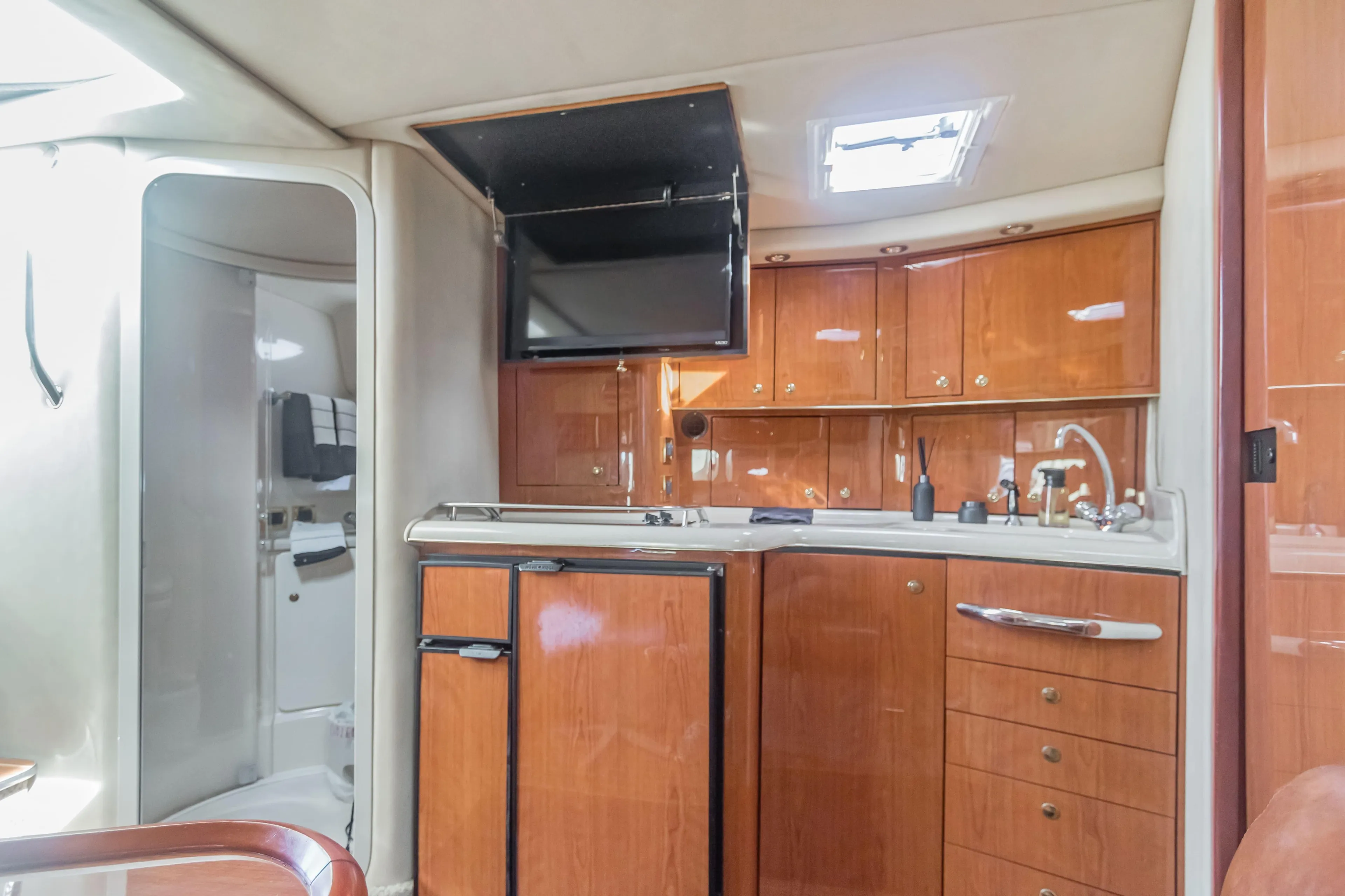 Interior of 2000 Sea Ray 370 Express Cruiser with wood cabinetry and compact kitchen.