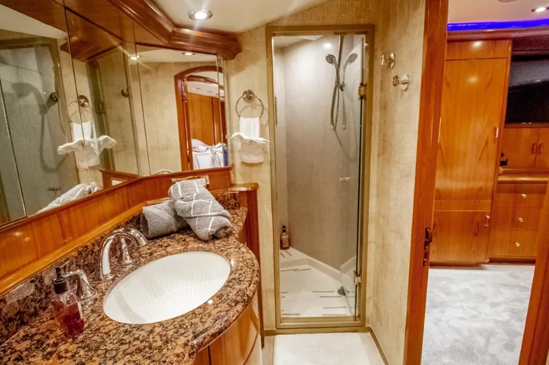 Reel Deal Yacht Photos Pics Luxurious 2005 Sea Force Sportfish bathroom with granite countertop and glass shower.
